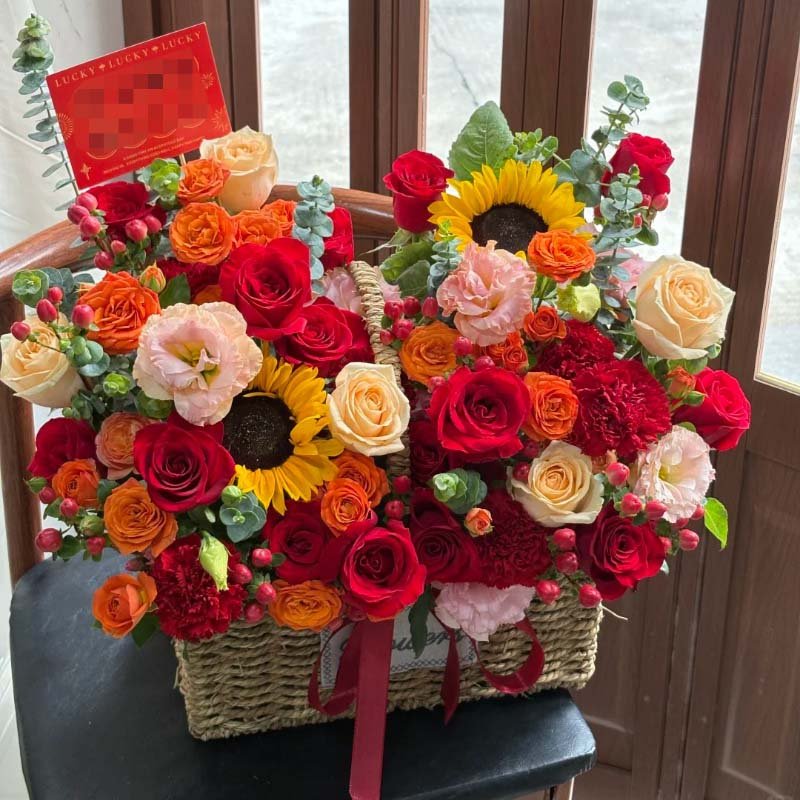 手提花篮A-16枝红玫瑰,16枝橙色泡泡,2枝向日葵,6枝红色康乃馨,5枝香槟玫瑰,6朵粉桔梗,红豆,尤加利;手提花篮