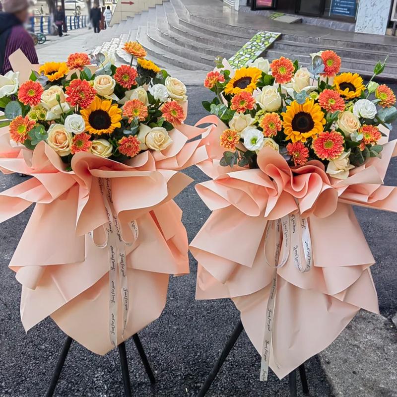 步步升高-8朵香槟玫瑰，3支向日葵，11支橘色扶郎花，3支白桔梗，尤加利间插。粉色包装束腰。